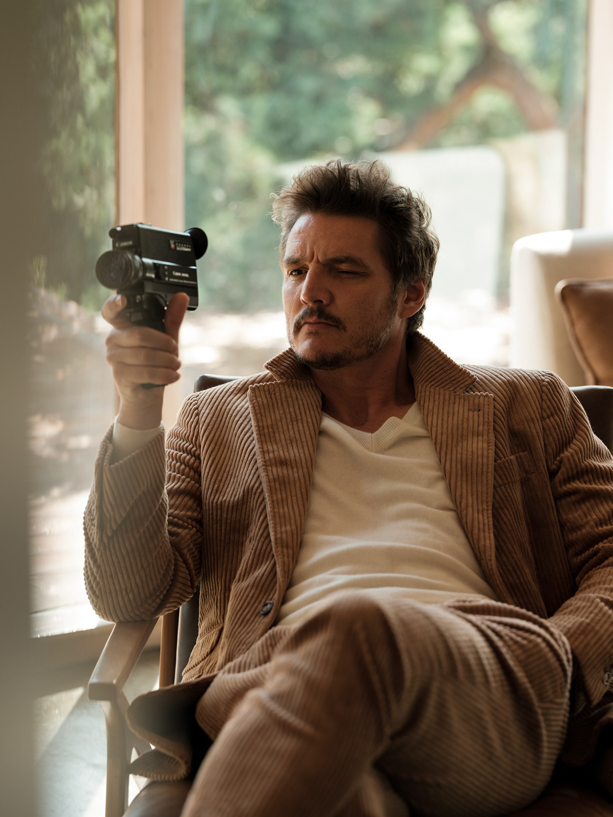 Pedro Pascal holds camera